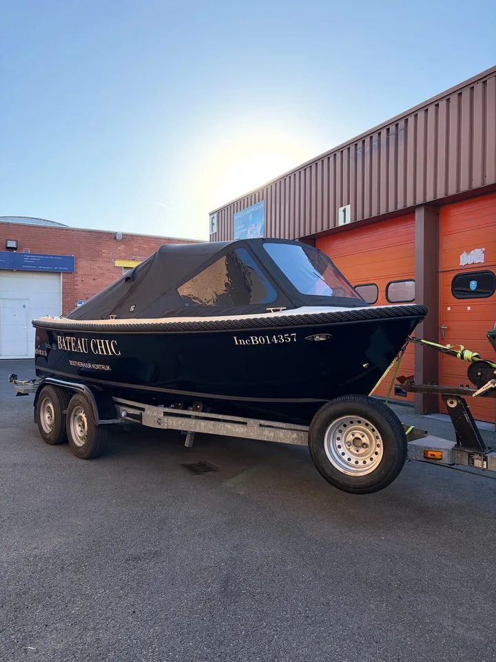 Belettering op een donkerblauwe boot op een aanhangwagen