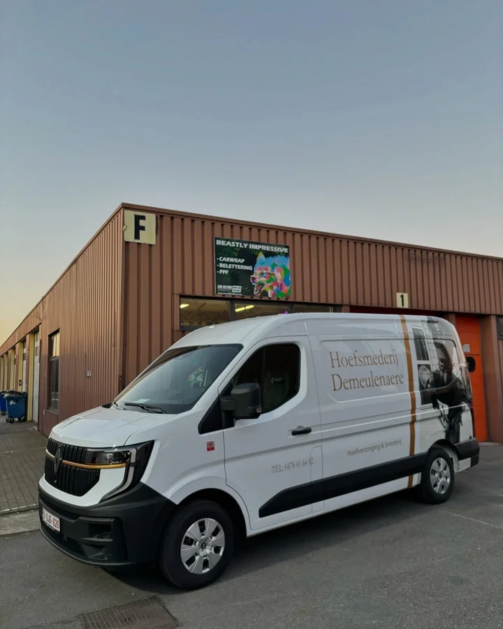 Bedrijfsbelettering met tekst en foto op een witte bestelwagen